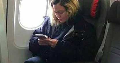 This 'normal' airplane passenger is actually a world famous singer! Do you see who it is?