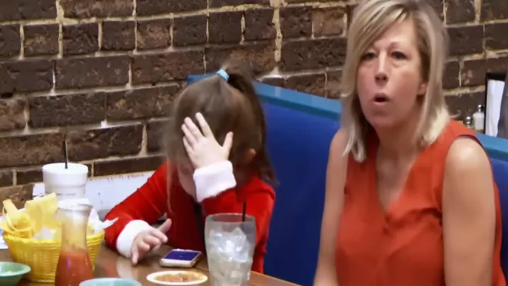 Una madre soltera y sus hijos en un restaurante no se dan cuenta de que hay un hombre sentado detrás de ellas