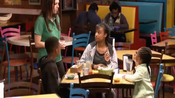 Mãe solteira e filhos em um restaurante não percebem que há um homem sentado atrás deles