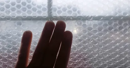 Er klebt Noppenfolie auf die Fensterscheiben. Der Wärmeeffekt ist wirklich enorm!