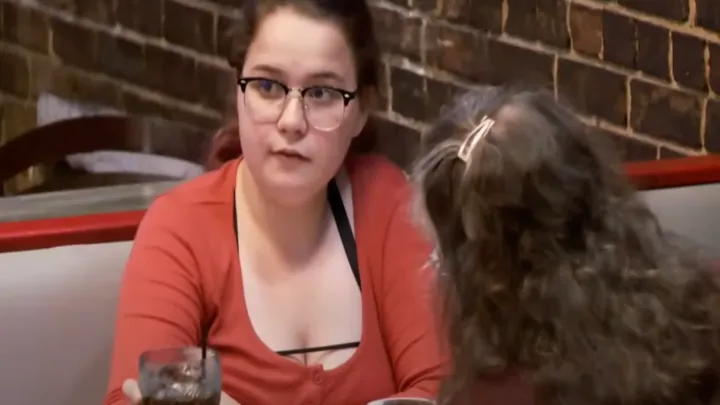 Mãe solteira e filhos em um restaurante não percebem que há um homem sentado atrás deles