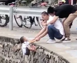Familieleden laten jongetje aan rand klif bungelen voor het perfecte kiekje