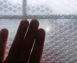 Er klebt Noppenfolie auf die Fensterscheiben. Der Wärmeeffekt ist wirklich enorm!