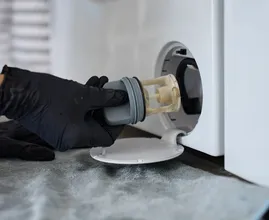 The little hatch at the bottom of your washing machine is the first thing repair technicians open, and most owners have never touched it