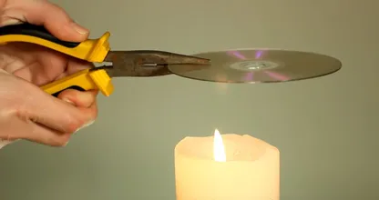 Ella está sosteniendo un viejo CD sobre una vela y está surgiendo algo hermoso