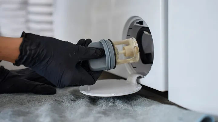 The little hatch at the bottom of your washing machine is the first thing repair technicians open, and most owners have never touched it