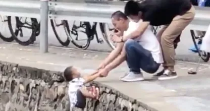 Familieleden laten jongetje aan rand klif bungelen voor het perfecte kiekje