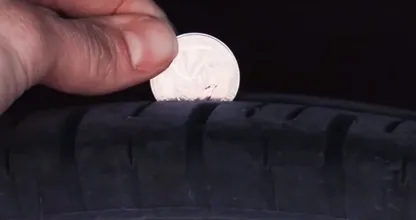 Gebruik een muntje om te controleren of je autobanden aan vervanging toe zijn